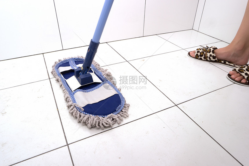 家庭主妇在浴室里用拖把洗瓷砖一般的公寓清洁女人在图片