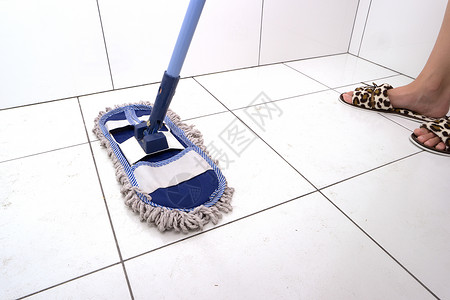 家庭主妇在浴室里用拖把洗瓷砖一般的公寓清洁女人在图片