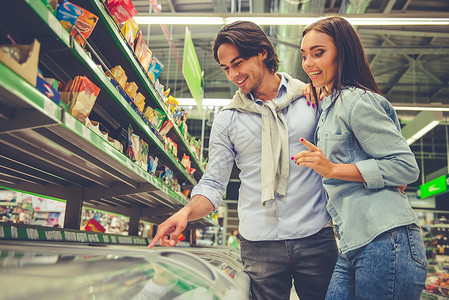 美年轻夫妇在超级市选择食物图片