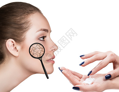 用手在皮肤干燥的妇女脸上涂奶油图片