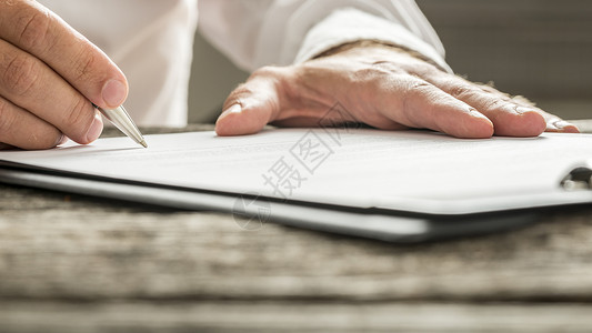 白衬衫男子签署商业文件或订书表格图片
