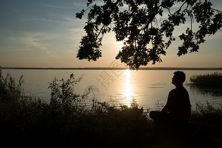 坐在湖边看日落的男人图片