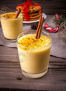 木制背景上的传统圣诞饮料蛋酒和饼干图片