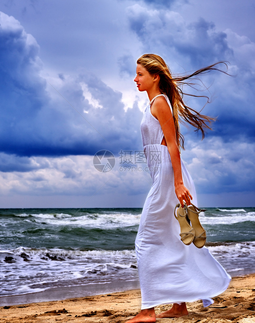 夏日少女海女孩走在沙滩海面上海下厚的云层图片
