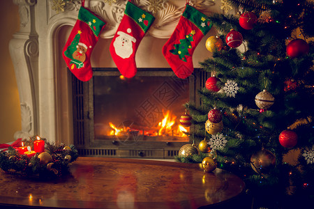 在装饰的壁炉和圣诞树前的空木桌的色调图像文本的地方适图片