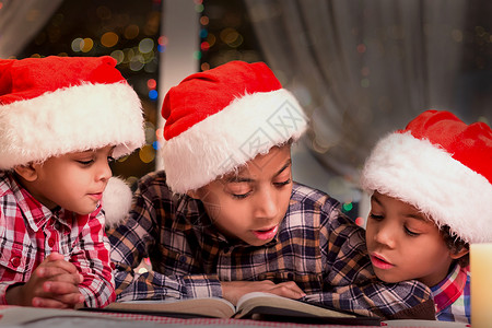 男孩在圣诞节读书孩子们戴着圣诞帽阅读晚上读圣诞故事平背景图片