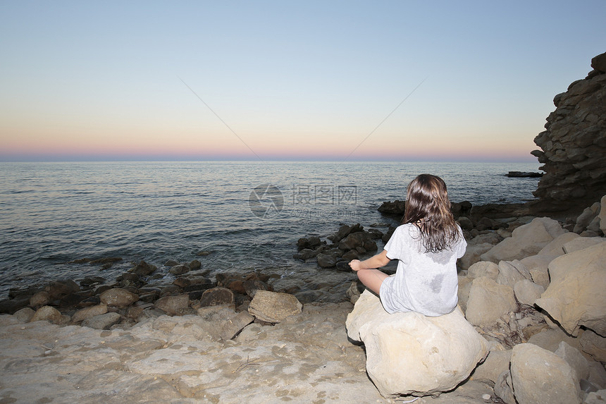 女孩在西班牙地中海的滩上冥想横向捕捉时有文字图片