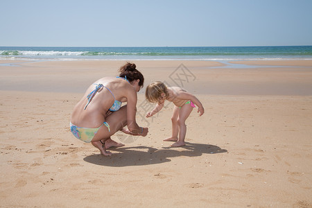 女妈或保姆蓝色比基尼在金沙滩海边寻找采图片