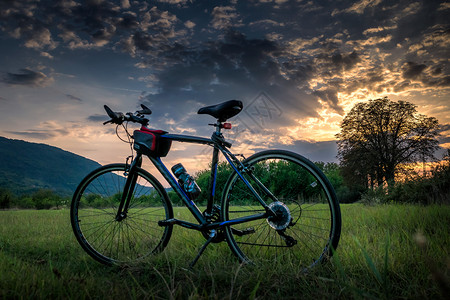 在日落和戏剧天空中骑自行车娱乐图片