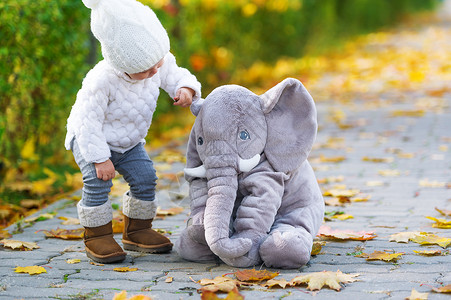 小女孩和玩具大象在秋图片