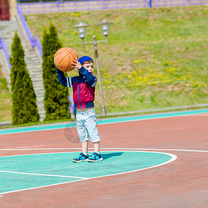 小男孩一个人在篮球场打球图片
