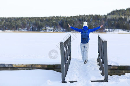 年轻女子在白冬森林中徒步旅行图片