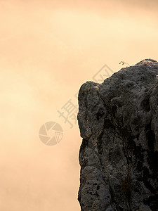 深沉雾谷上方的尖沙石悬崖岩层从浓图片