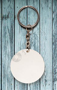木制背景上带圆形小饰品的钥匙圈背景图片