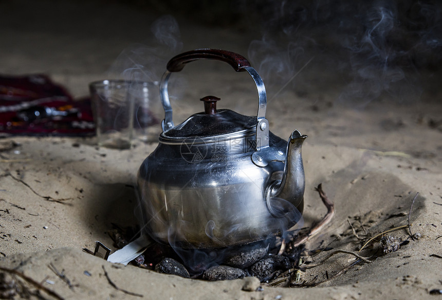 沙子上的传统金属茶壶图片