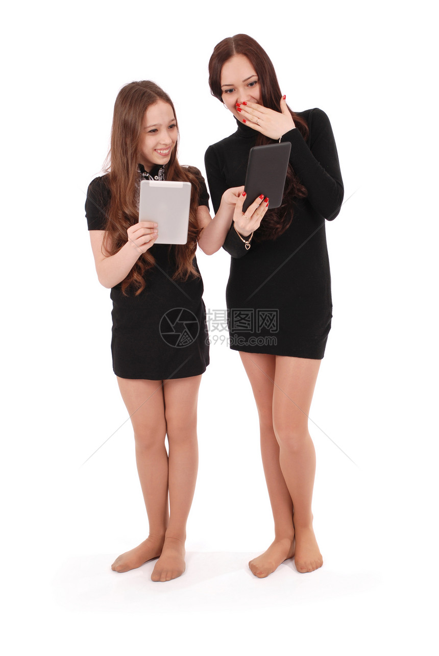 两个学生少女持有平板电脑交换新闻在白图片