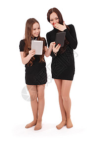 两个学生少女持有平板电脑交换新闻在白图片