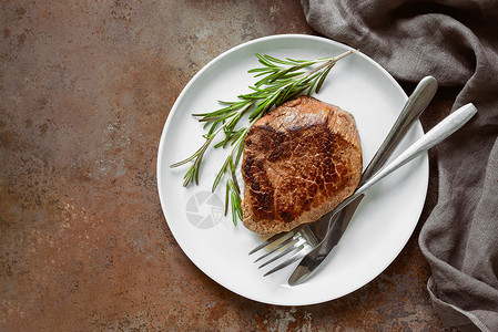 牛肉排配有迷迭香用白色的盘子供图片