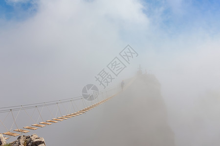 男子在雾中穿过悬吊桥上的裂缝重心图片