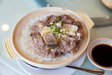 的蒸猪肉和粘土锅中的咸鱼米是香港和南部广东小餐馆中流行的背景图片