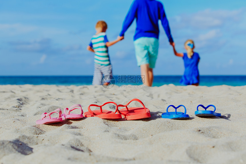 父亲与儿子和女儿在海滩散图片