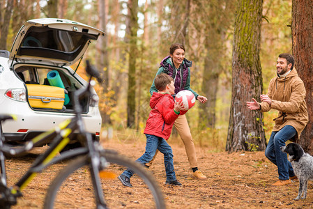 幸福的家庭玩球在秋森林家庭出游图片