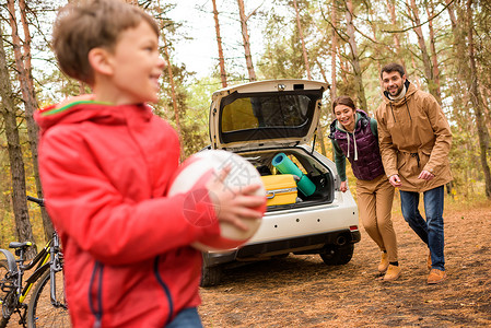 幸福的家庭玩球在秋森林家庭出游图片