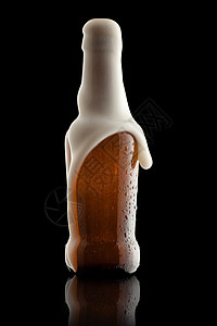 从溢出的啤酒瓶中流出泡沫图片