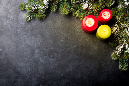 黑色石块桌上的圣诞蜡烛和雪佛树图片