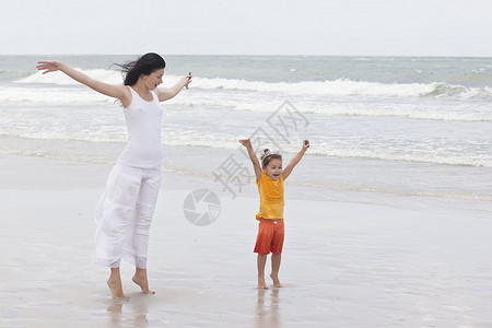 沿着热带海滩散步的母女图片