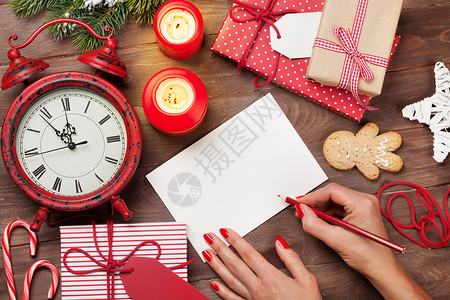 女写圣诞节贺卡和挂在木制桌子图片