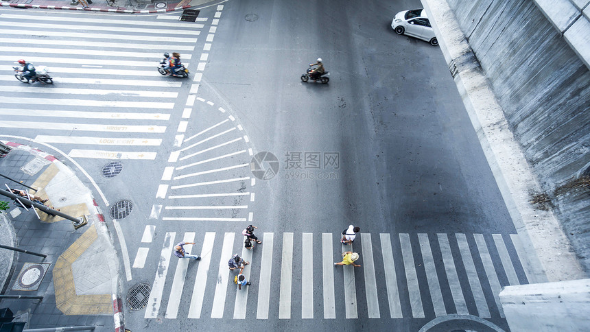 白天在城市道路上行驶的人和汽车图片