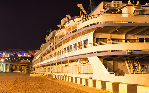 老客船停泊在乌克兰敖德萨港的码头码头旁边五颜六色的灯光在背景图片