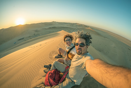 成年夫妇在纳米布沙漠的沙丘上自拍图片