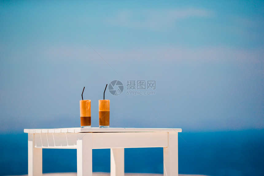 海背景木桌上的拿铁咖啡图片