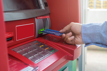 atm取款男手使用和插入ATM卡到银行机器取款的特写背景