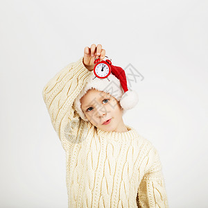 快乐美丽的小男孩在白色背景下戴着圣诞老人帽子的画像新年图片