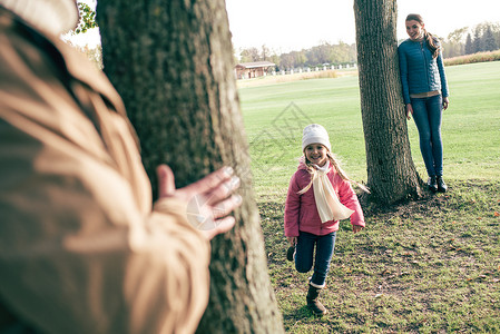 快乐的父母在秋天公园与笑的小女儿图片
