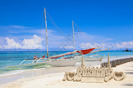菲律宾博拉凯岛白滩上的沙城堡和木图片