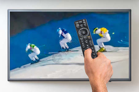 男人在电视上看冬季滑雪手握图片