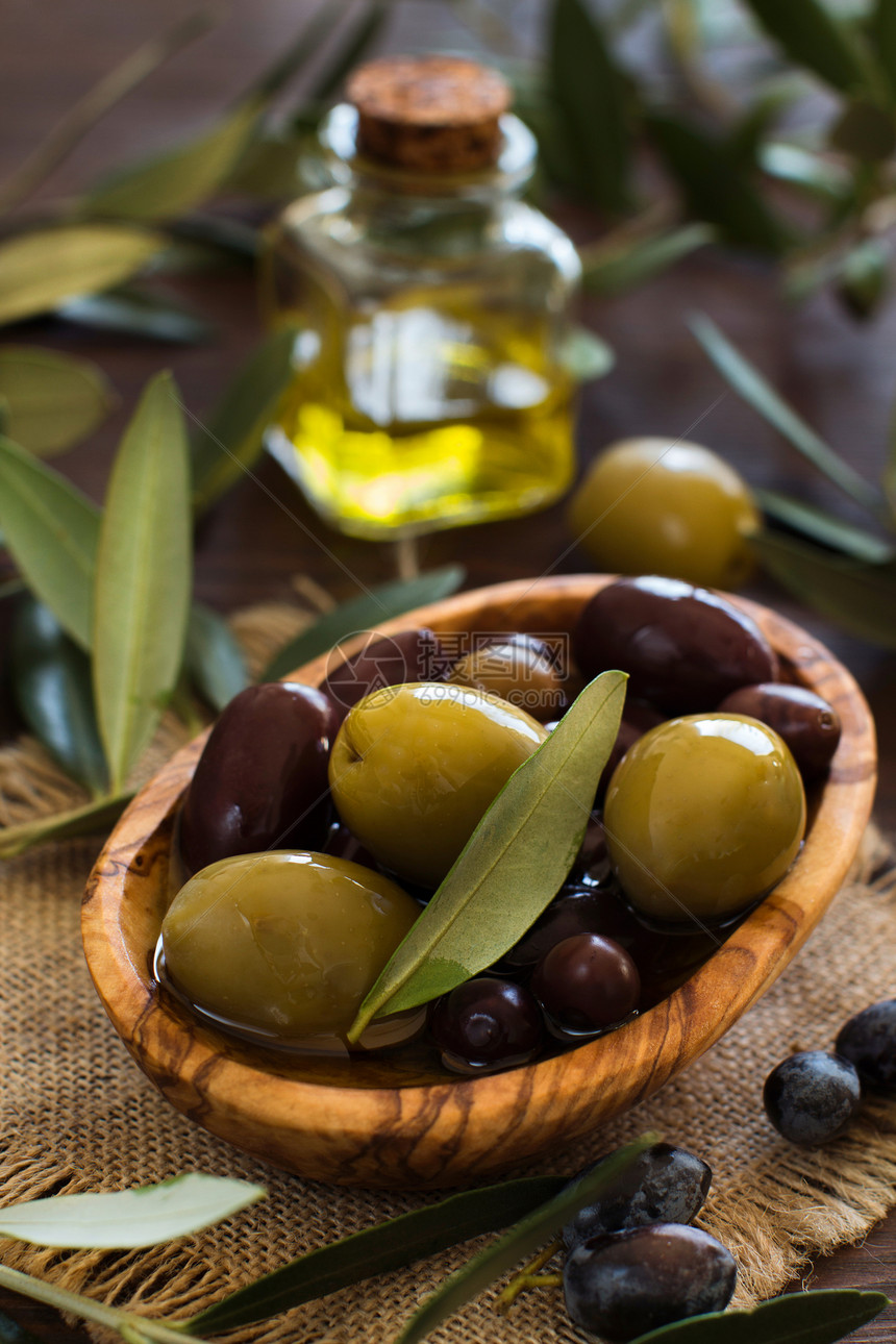 乡村木背景上的橄榄油和橄榄图片