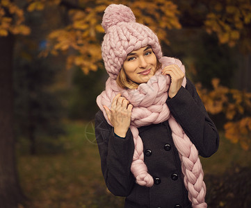 美丽的年轻女子身着美意羊毛面糊的彩色帽子和围巾图片