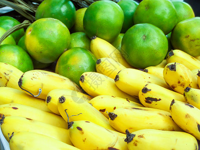 市场背景中篮子上的香蕉和橙子图片