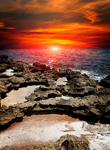 海上石头上的红色日落图片