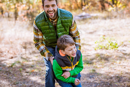 快乐的父亲和儿子在秋天公图片