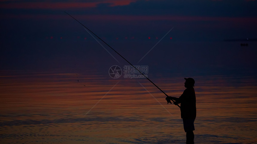 渔民在宁静的海洋上的轮廓图片