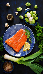 生鲑鱼片和蓝盘烹饪的原料图片
