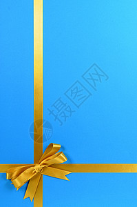 蓝色背景上的金色礼品丝带图片