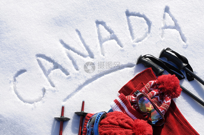 加拿大在雪上用滑雪杆护目镜和帽图片