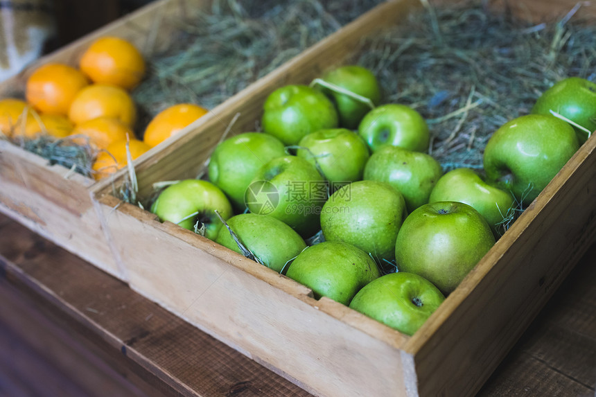 商店木箱中的新鲜青苹果和葡萄柚图片